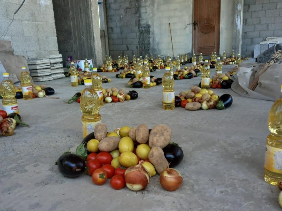 AISHA food aid packages including fresh vegetables and oil being prepared.